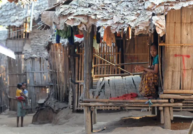 ผู้ลี้ภัยชาวกะเหรี่ยง (ขวา) นั่งอยู่ในที่พักพิงของเธอที่ค่ายผู้ลี้ภัยแม่sหละใน อ.แม่สอด จ.ตาก ใกล้ชายแดนไทย-เมียนมา ภาพนี้ถ่ายเมื่อปี 2012