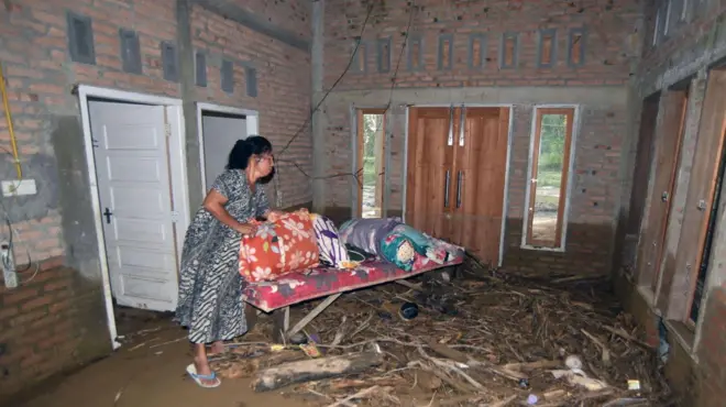 Warga berada di rumahnya yang masih berlumpur akibat banjir bandang di Lapau Munggu, Kuranji, Padang, Sumatera Barat, Selasa (4/8/2026).