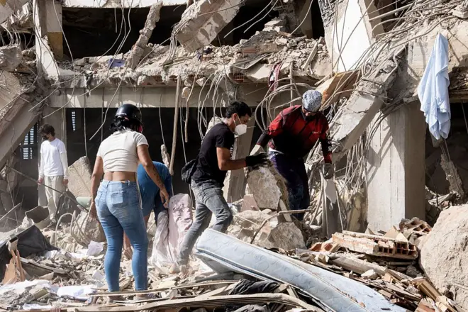 Familiares y voluntarios buscan entre los escombros después de que dos edificios de 17 plantas del complejo residencial Belo Horizonte se derrumbaran en Catia La Mar, La Guaira (Venezuela), el 26 de junio de 2026.