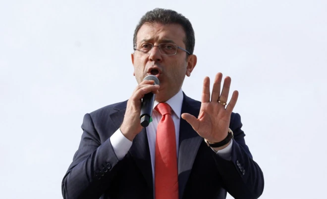 Ekrem İmamoğlu, İstanbul'daki Çağlayan'daki adliye önünde destekçilerine hitap ediyor. Elini kaldırmış konuşuyor