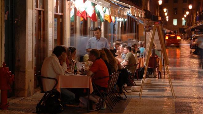 Pessoas jantando em tradicional rua da cidade de Lisboa