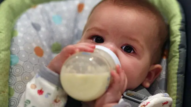 बोतल से दूध पीता एक बच्चा