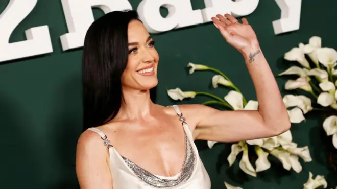 Кејти Пери у белој хаљини са сребрним детаљима маше пред фотографисање