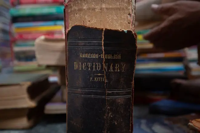 The broken spine of the first edition of Lutheran priest Reverend Ferdinand Kittel's Kannada-English dictionary published in 1894 is seen on the floor of the Anke Gowda Jnana Prathistana (Knowledge Shrine) on August 05, 2025 in Kennalu village, near the southern city of Mysuru, India.
