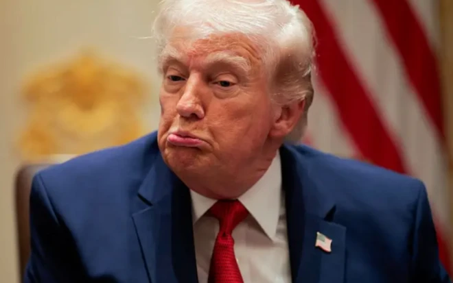 Foto mostra Donald Trump usando terno azul marinho, camisa branca e uma gravata vermelha e faz um gesto com os lábios em sinal de frustração ou tédio
