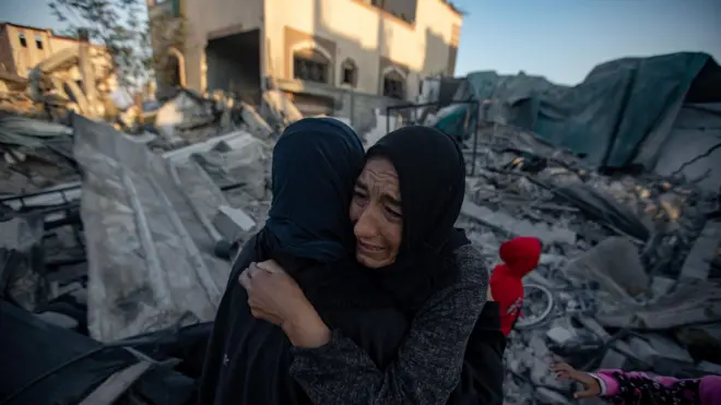 سيدات يبكين في غزة وسط الدمار