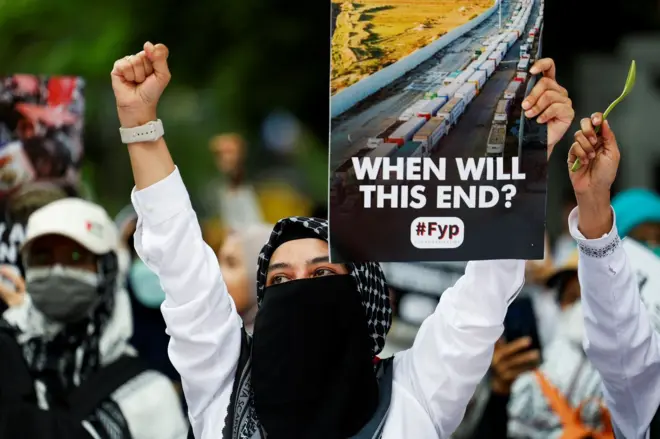 متظاهرة تحمل لافتة تقول متى سينتهي هذا؟