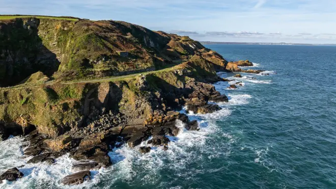 왼편에 산과 트레킹 코스가 있으며 오른편에 바다가 있다