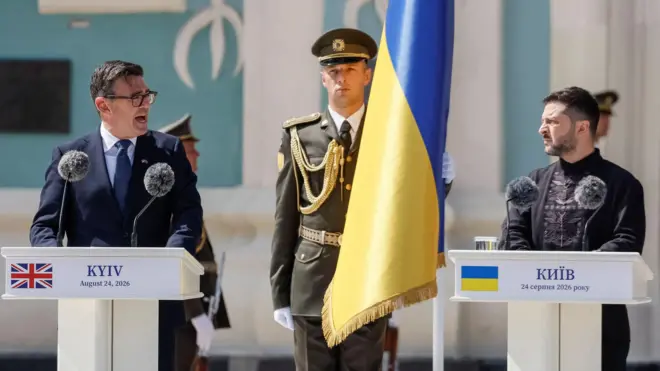 Енди Барнам (лево) и Владимир Зеленски (десно), а између њих је украјинска застава