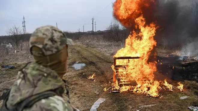 تصویر سربازی از پشت سرکه به آتش نگاه می‌کند
