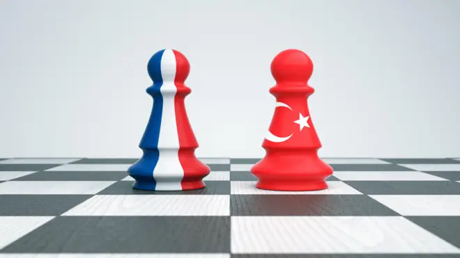 Satranç tahtasında üzerlerinde Fransa ve Türkiye bayrakları olan iki piyon karşı karşıya geliyor