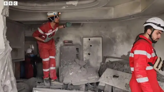 破壊されたテヘランのビルの中で作業する赤新月社の救急隊員