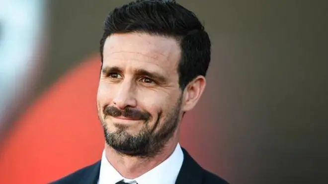  Джеймс Ренсон у піджаку і білій сорочці