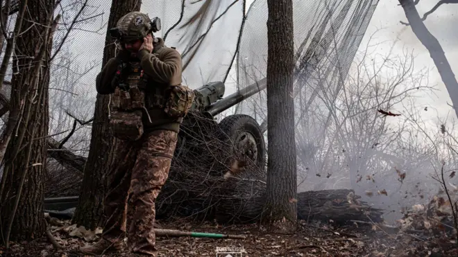 Украинский военный стреляет из гаубицы 