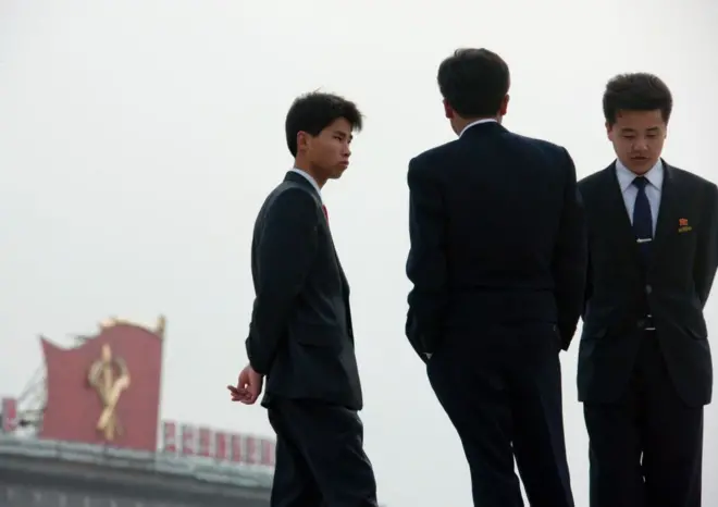 양복을 입은 세 명의 젊은 북한 남성