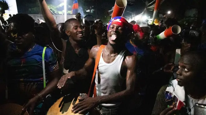 Haiti fans celebrating, with one banging a drum