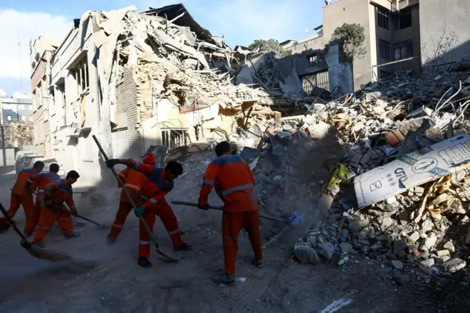 People clear rubble of a Synagogue, which was damaged in a strike, from a street, amid the U.S.-Israeli conflict with Iran, in Tehran, Iran, April 7, 2026.