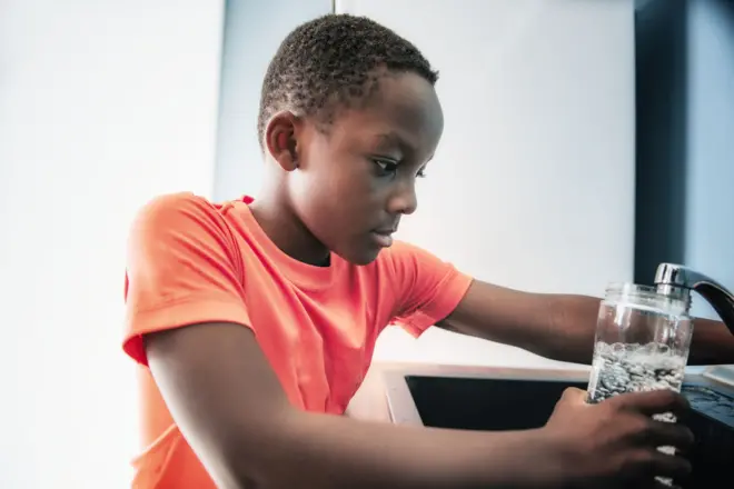 Enfant qui prend de l'eau de robinet