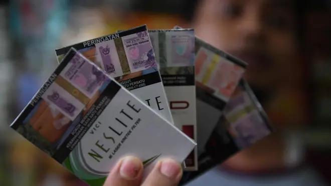 Pedagang menunjukkan cukai rokok yang di jual di Jakarta, Sabtu (5/11/2022). 