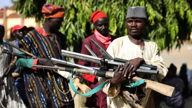 Three men wey carry guns for hands