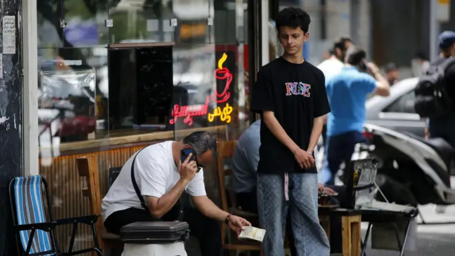شخص يحمل في يده أوراقاً نقدية إيرانية في طهران