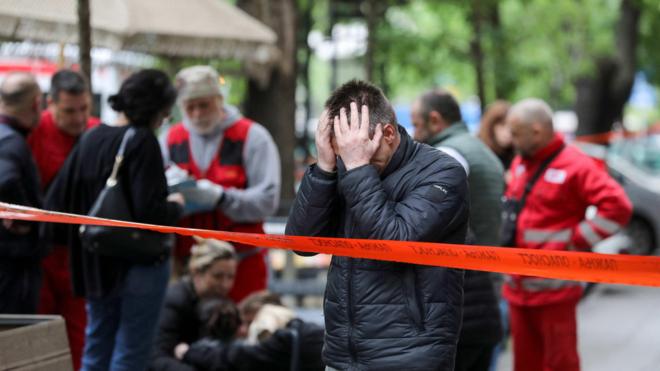 Um homem pondo as mãos na cabeçatimemania loterias caixafrente à escola onde um adolescentetimemania loterias caixa13 anos matou a tiros oito colegas e um segurança do colégio