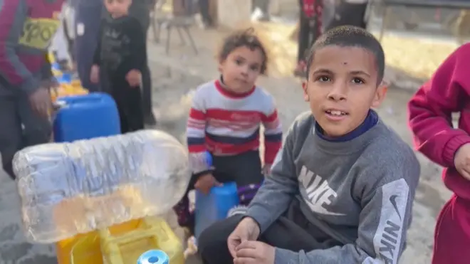 طفل من غزة ينتظر تعبئة مياه الشرب