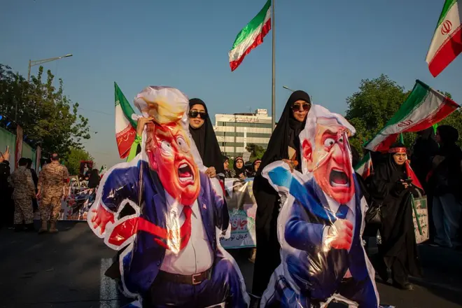 نساء يرفعن صوراً كاريكاتورية للرئيس الأمريكي دونالد ترامب ورئيس الوزراء الإسرائيلي بنيامين نتنياهو، خلال تظاهرة مؤيدة للحكومة بمناسبة يوم الجيش الوطني، في 17 أبريل/نيسان 2026 في طهران، إيران.