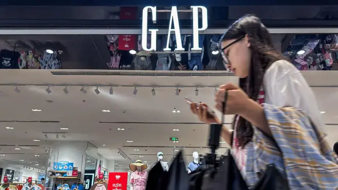 Una joven pasa por delante de una tienda de Gap en China.