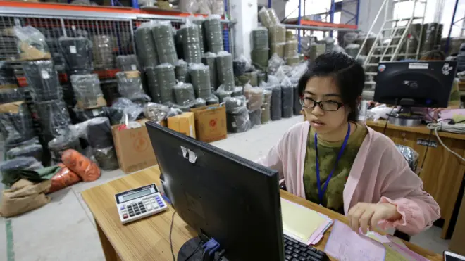 广州某工厂内一位女性工作人员在电脑上处理发往美国的货物(资料图片)