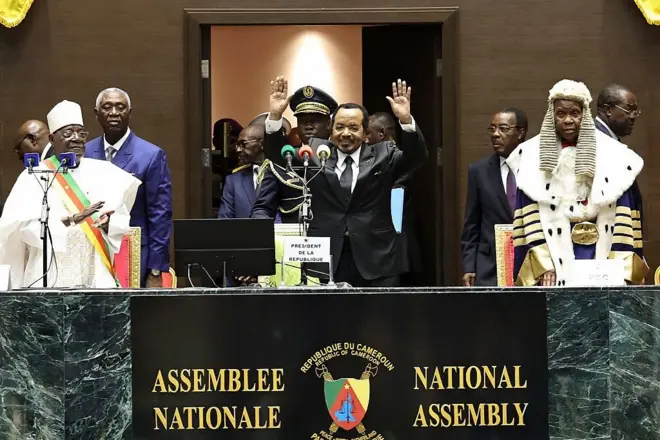 Le président camerounais Paul Biya (au centre) fait un geste à son arrivée à la cérémonie d'investiture à l'Assemblée nationale de Yaoundé, le 6 novembre 2025.