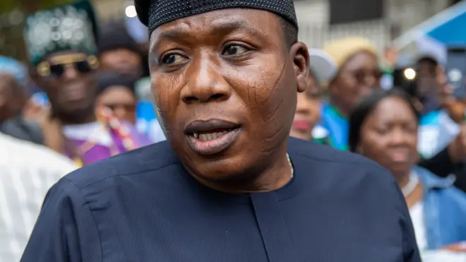 Sunday Adeyemo tawọn eeyan mọ si Igboho Ooṣa ree, o de fila dudu kan to n dan, ẹwu alawọ eeru lo wọ. Aworan naa ṣafihan ila oju rẹ ketekete, Igboho n sọrọ lọwọ ninu fọto naa, bẹẹ ni ero pọ lẹyin rẹ yẹyẹ.