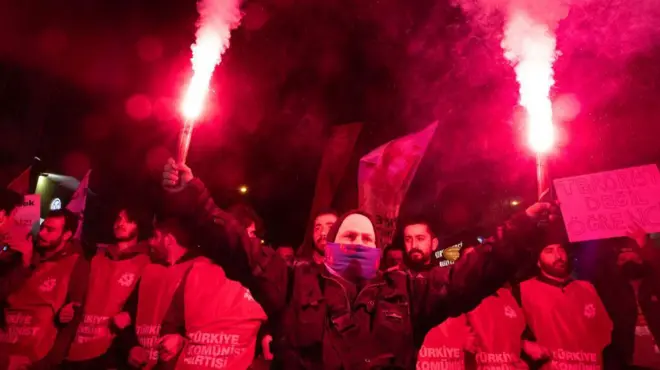Protesters light flares during clashes on 23 March 2025 in the Turkish capital, Ankara