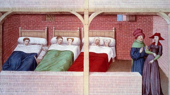 Un dormitorio en 1450, con varias camas que tienen dos ocupantes cada una