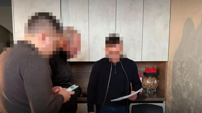 Фото трьох чоловіків у квартирі, їхні обличчя розмиті