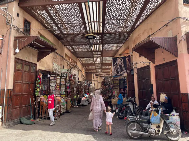 Centro de Marraquexe mostra várias pessoas na rua.