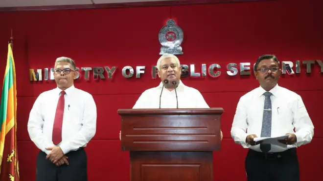 හිටපු මහජන ආරක්ෂක ඇමති ටිරාන් අලස් සහ හිටපු ආගමන හා විගමන පාලක ජනරාල් හර්ෂ ඉලුක්පිටිය රතු පැහැ පසුබිමක පවත්වන මාධ්‍ය හමුවක් 