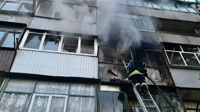 Пожежний лізе у вікно, звідки йде дим 