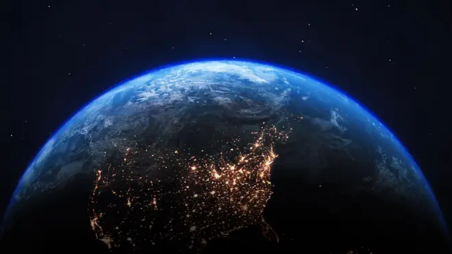 अवकाशातून टिपलेला पृथ्वीच्या उत्तर गोलार्धाचा एक फोटो, ज्यामध्ये काही भूभाग विद्युत रोषणाईने उजळलेले दिसत आहेत.