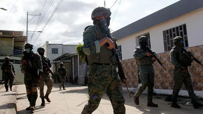 Miembros de las Fuerzas Armadas de Ecuador, vestidos de camuflaje y portando armas largas, patrullan las calles de la localidad de Manta.