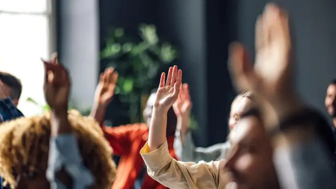 Pessoas com mãos levantadas