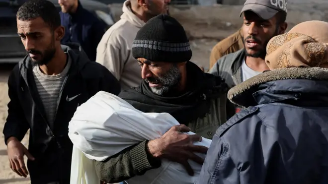 رجل يحمل جثة ابنه في غزة