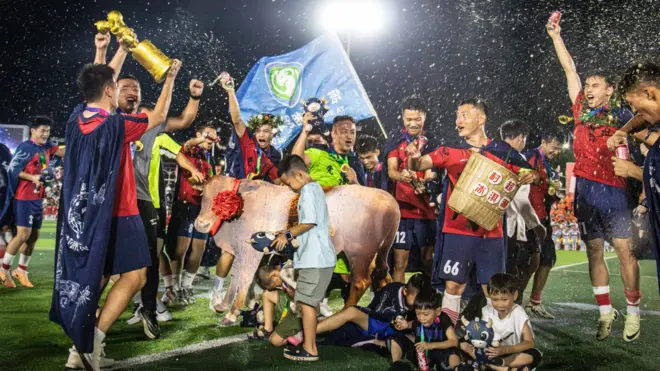 Chinese local football team celebrating tournament victory