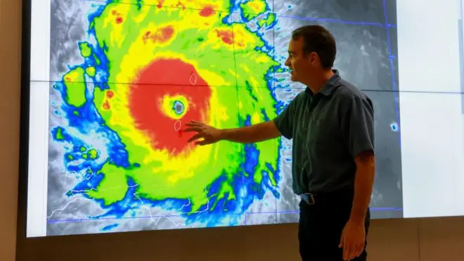 Un funcionario de meteorología de EE.UU. señala un gráfico de un huracán