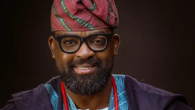 Kunle Afolayan wọ agbada aṣọ oke, o si de fila pẹlu ilẹkẹ lọrun