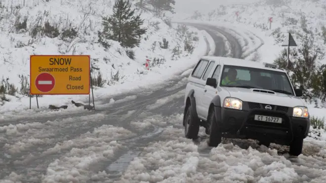 Snow for road wit vehicle parked by di side