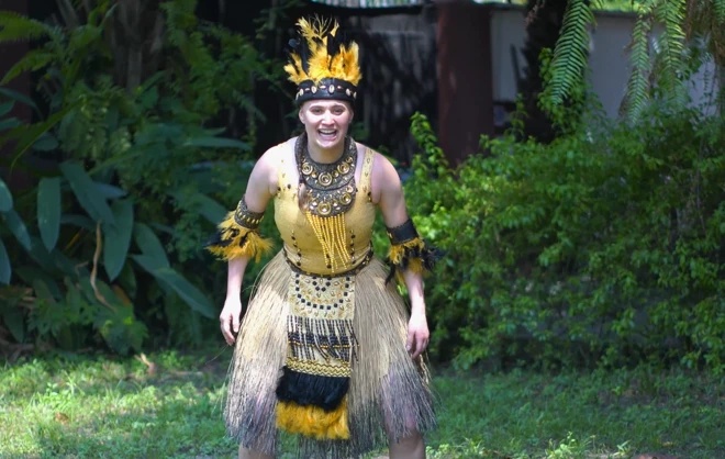 Woman stand in yellow traditional attire looking straight