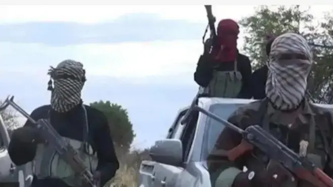 Awon agbebọn to gbe ibọn dani, bo oju wọn duro siwaju ọkọ ninu igbo, ẹnikan wa ninu ọkọ naa ninu wọn