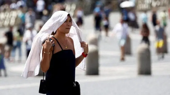 سيدة تسير خلال موجة حارة إيطاليا.