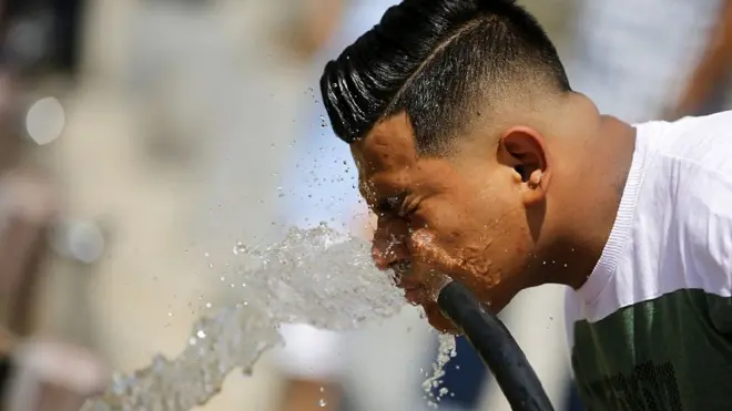 Un hombre trata de refrescarse con agua